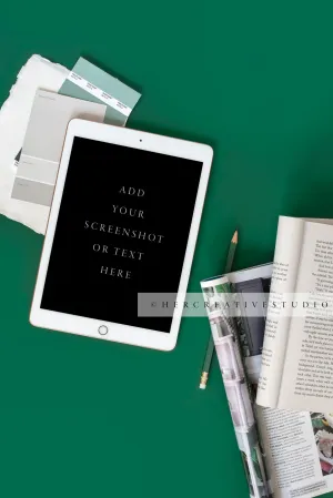 Tablet & Book on Green Background. Digital Image